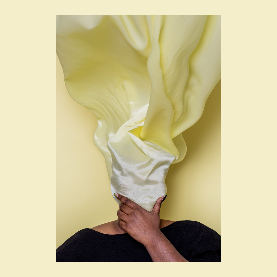 afbeelding van vrouw onder geel doek met hand rustend op kind