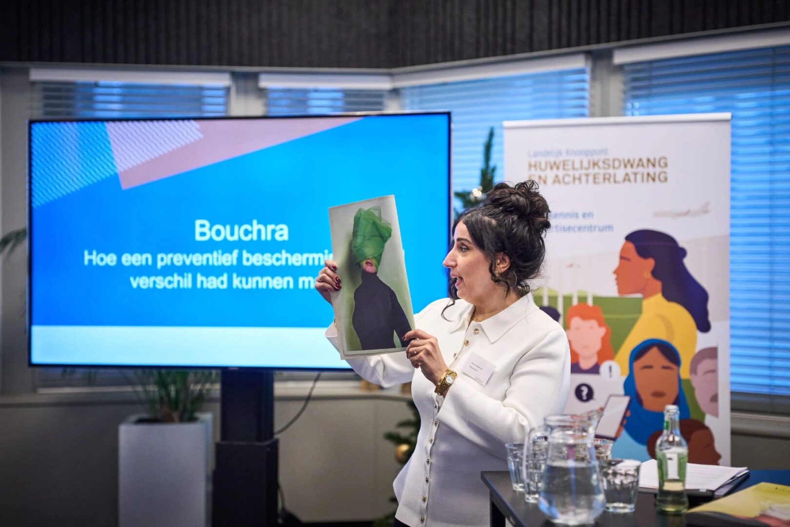 presentatrice Samira el Kandoussi houdt brochure omhoog